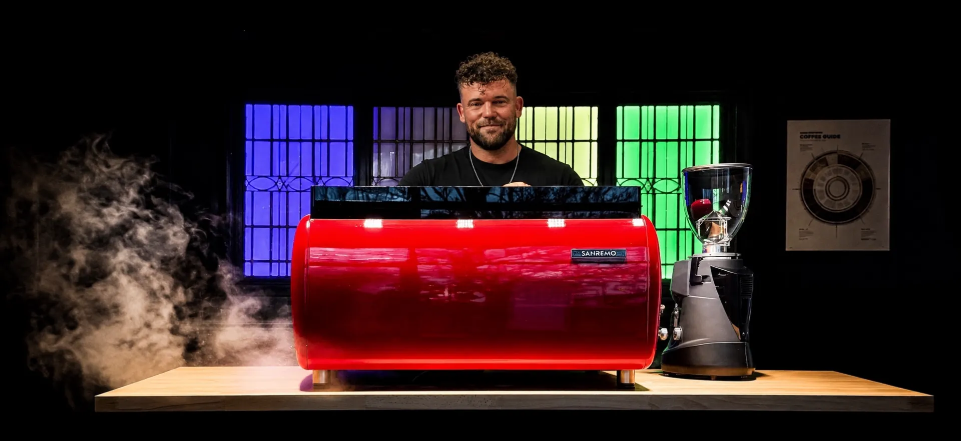 Duane behind a red Sanremo coffee machine at Broadway Coffee Roasters
